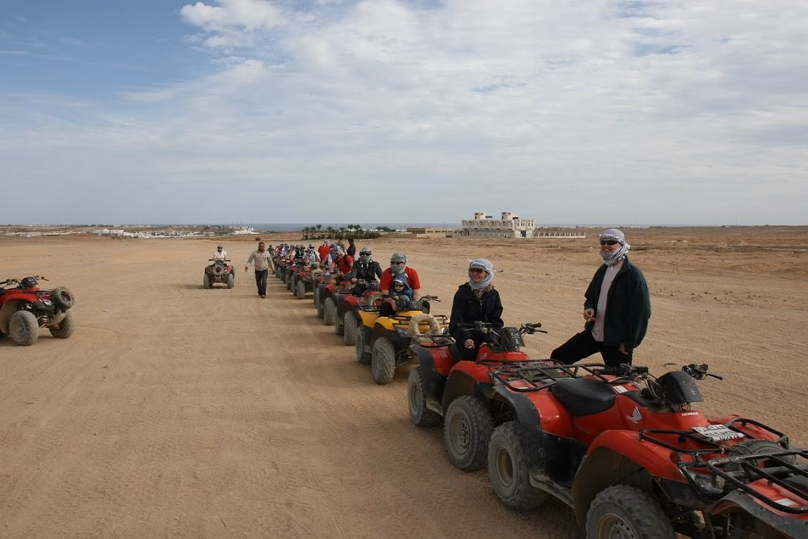 Een rij quads met deelnemers met hoofddoeken in de woestijn bij Hurghada