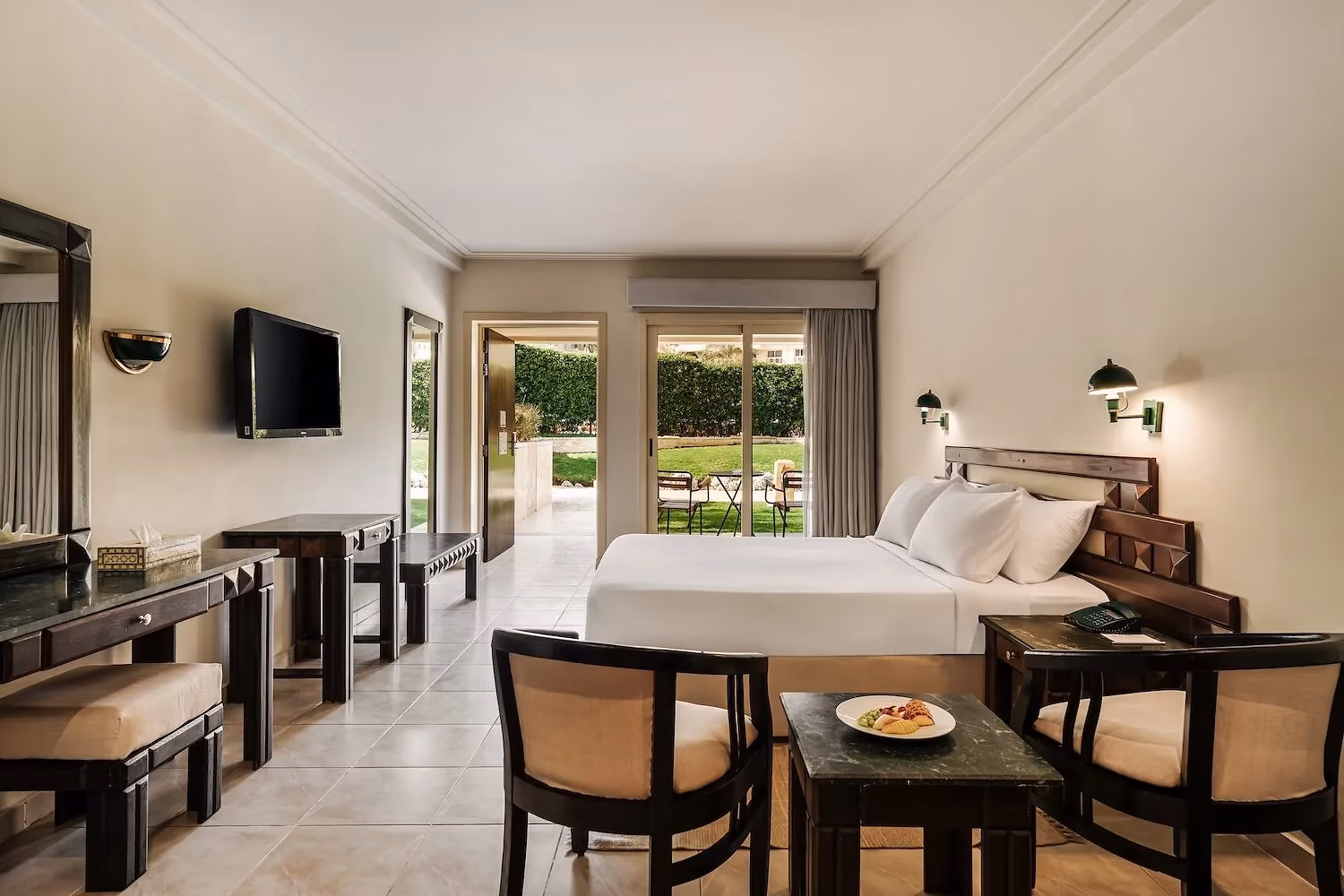 Aangepaste kamer met tweepersoonsbed en een brede deur naar de tuin in Hotel Sindbad Club in Hurghada