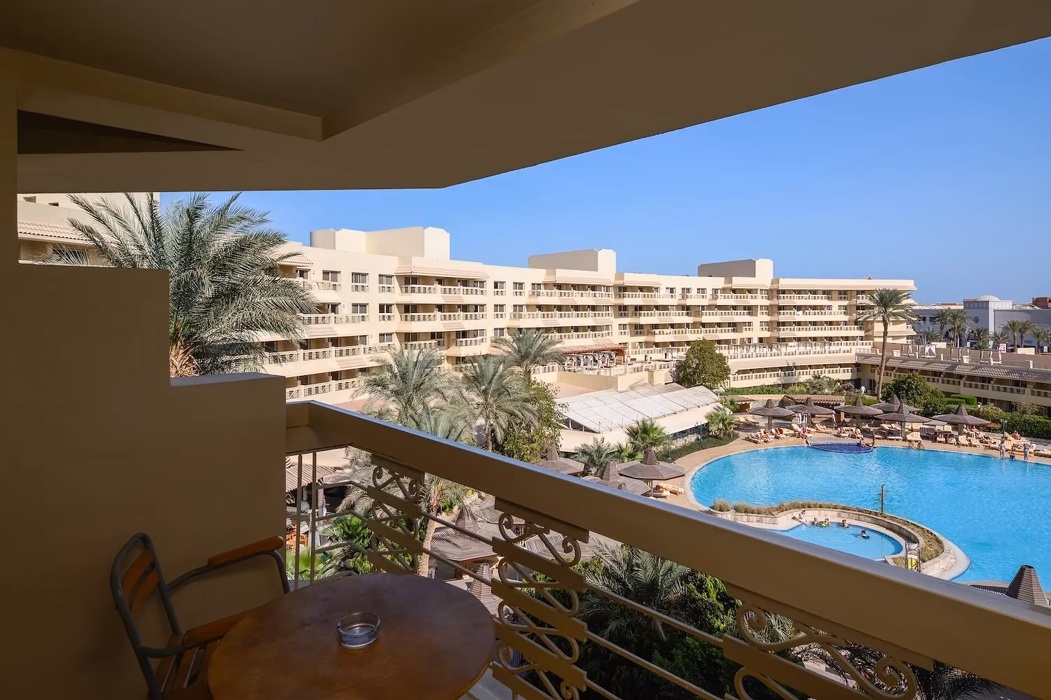Balkon met zitje en uitzicht op het hoofdzwembad en de hotelvleugels van Hotel Sindbad Club in Hurghada