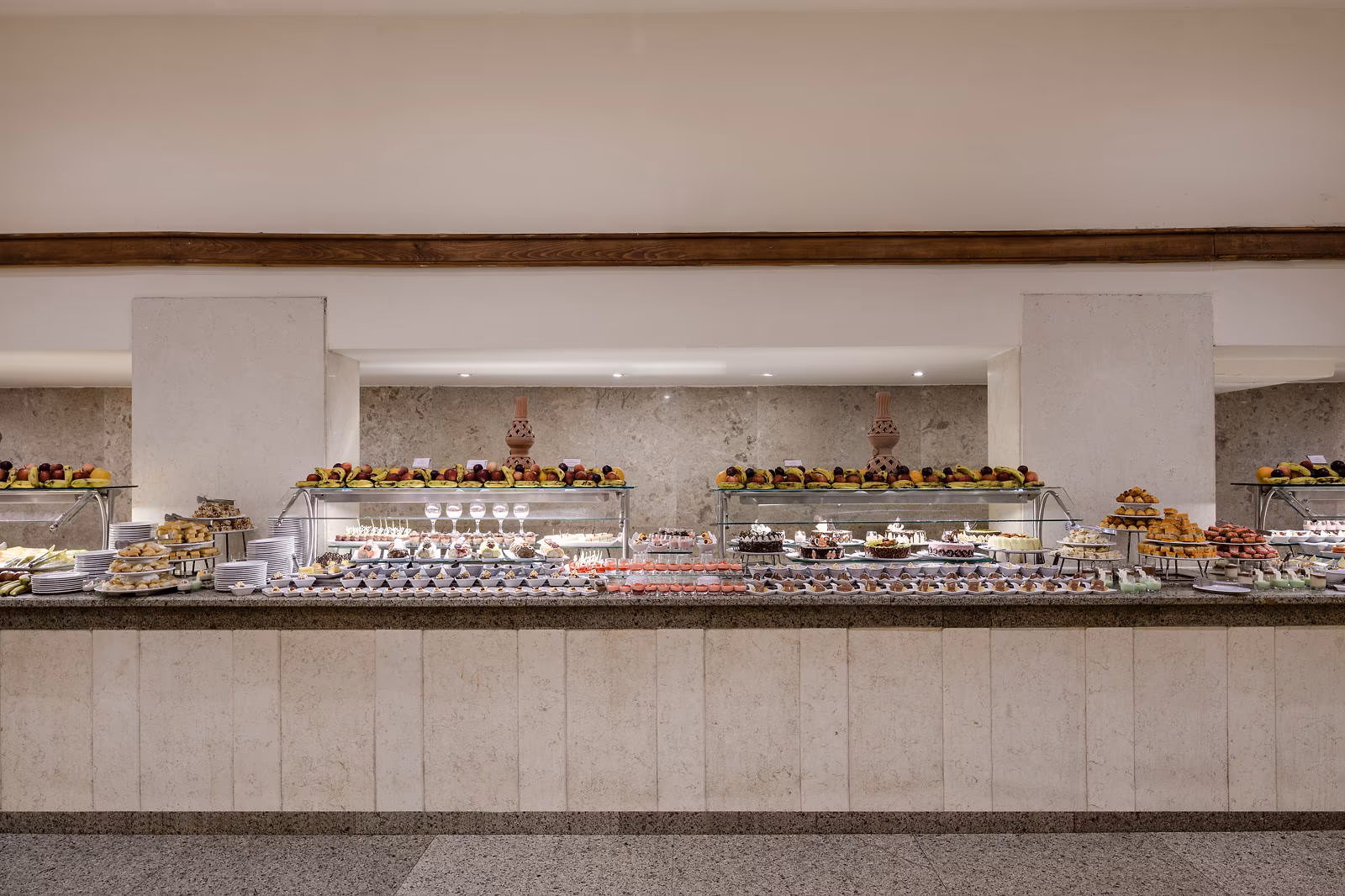 Buffet met fruit, taartjes en gebak op een lange marmeren toonbank in Hotel Sindbad Club in Hurghada