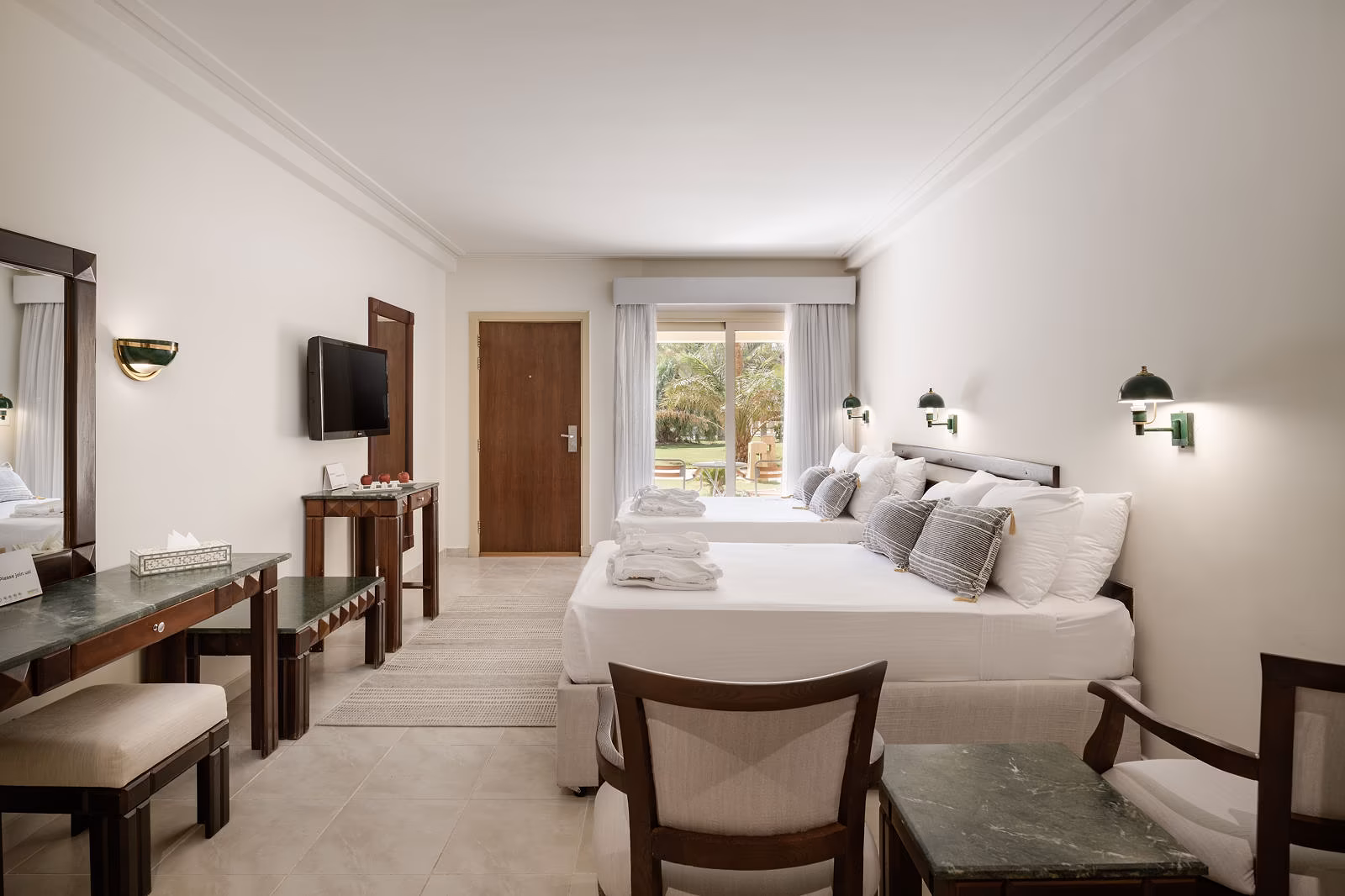 Deluxe familiekamer met twee tweepersoonsbedden en een deur naar het tuinterras in Hotel Sindbad Club in Hurghada