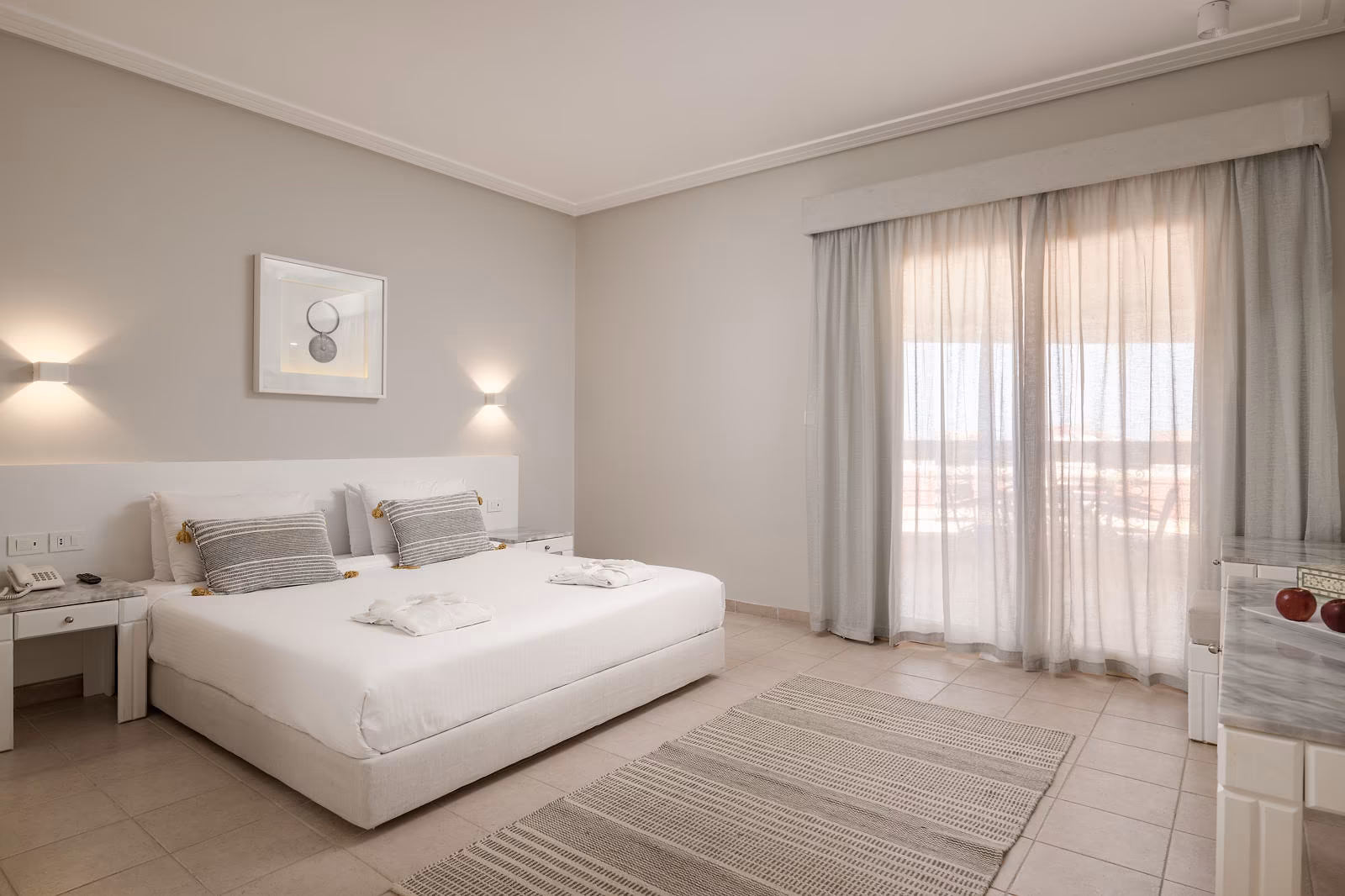 Hoofdslaapkamer van de Deluxe familiesuite met kingsize bed en vitrage voor de balkondeur in Hotel Sindbad Club in Hurghada