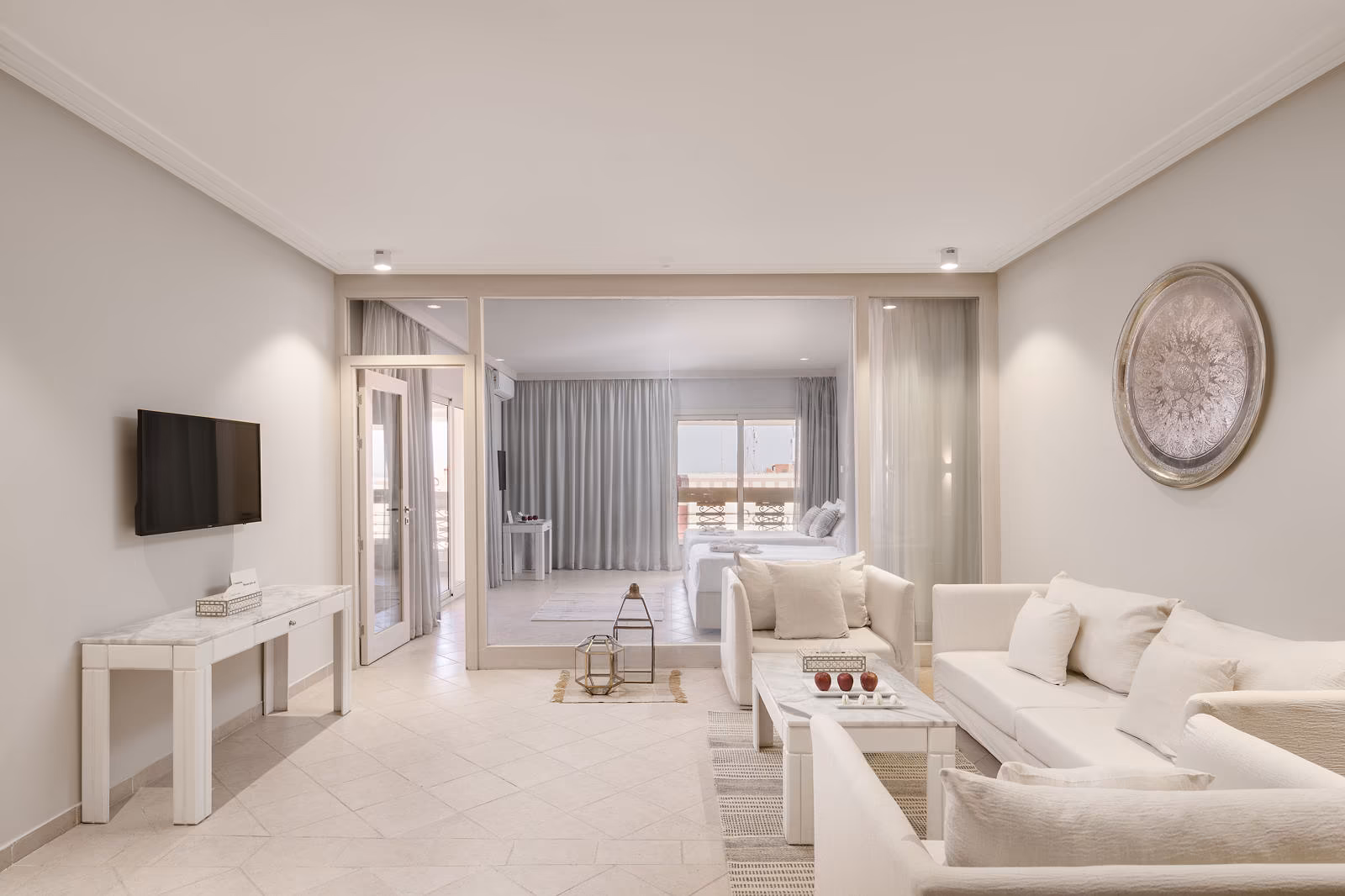 Woonkamer van de Deluxe familiesuite met witte banken en glazen deuren naar de slaapkamer in Hotel Sindbad Club in Hurghada