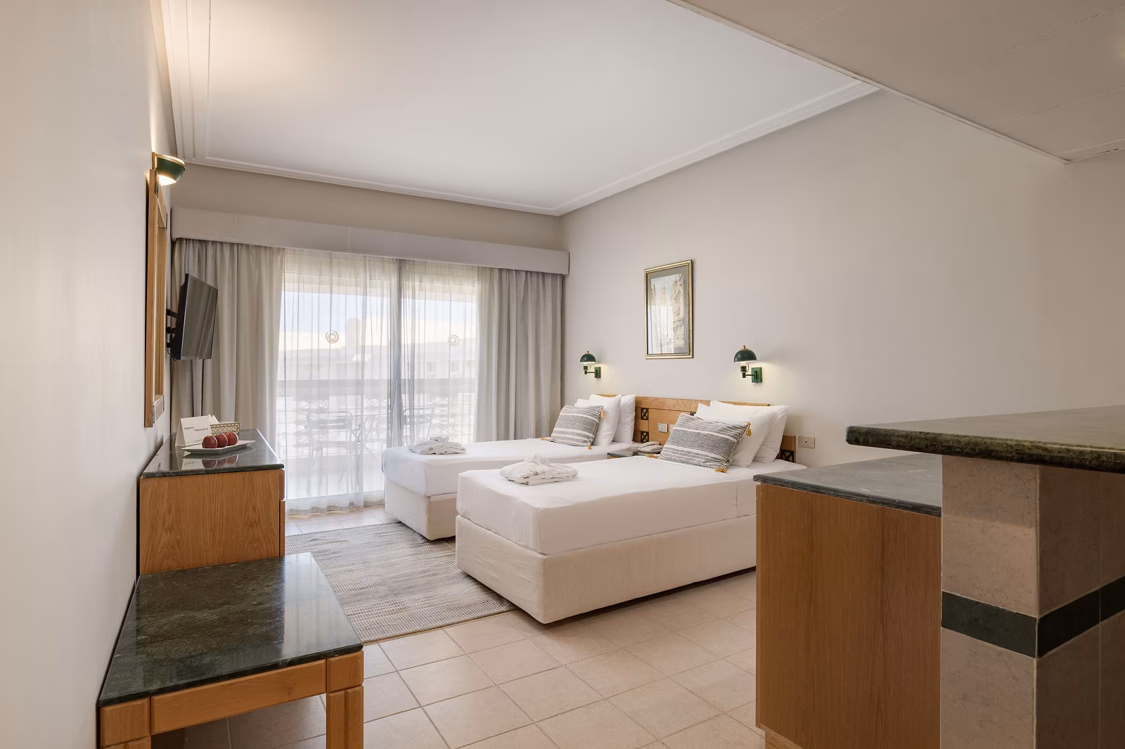 Kamer met twee eenpersoonsbedden, houten meubels en een balkon in Hotel Sindbad Club in Hurghada