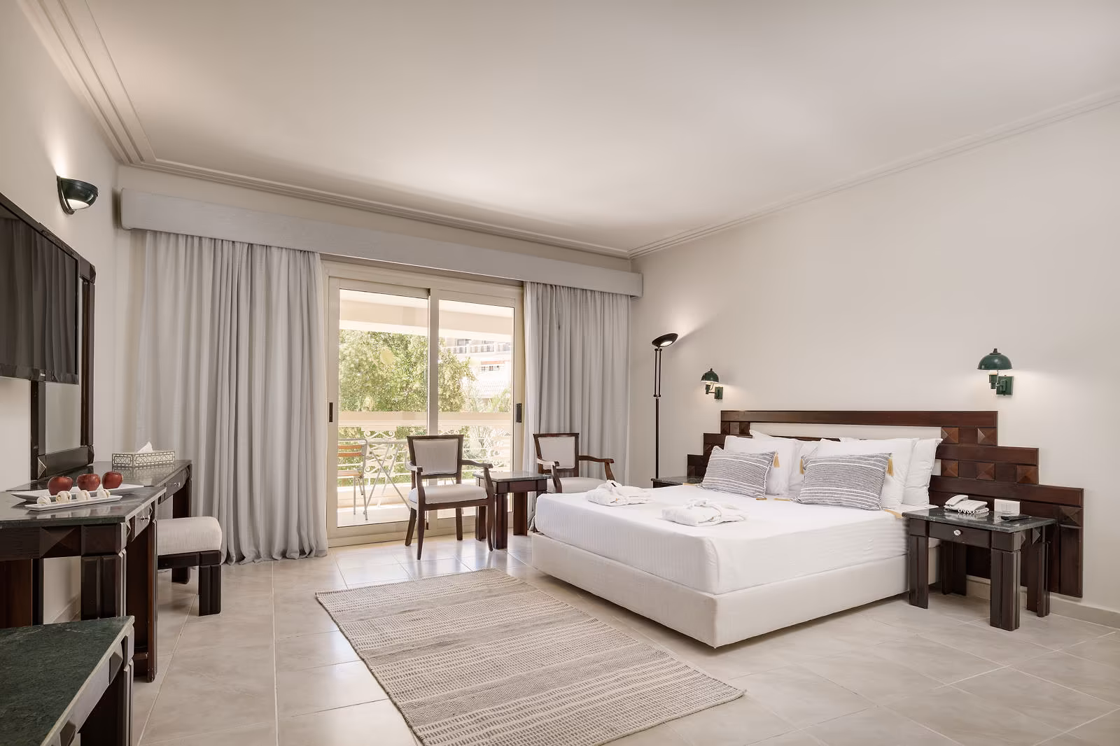 Premium kamer met tweepersoonsbed, donkerhouten hoofdbord en balkondeur naar de tuin in Hotel Sindbad Club in Hurghada
