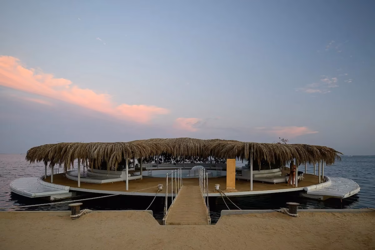 Steiger naar een ronde lounge met rieten dak op het water bij het strand van Hotel Sindbad Club in Hurghada