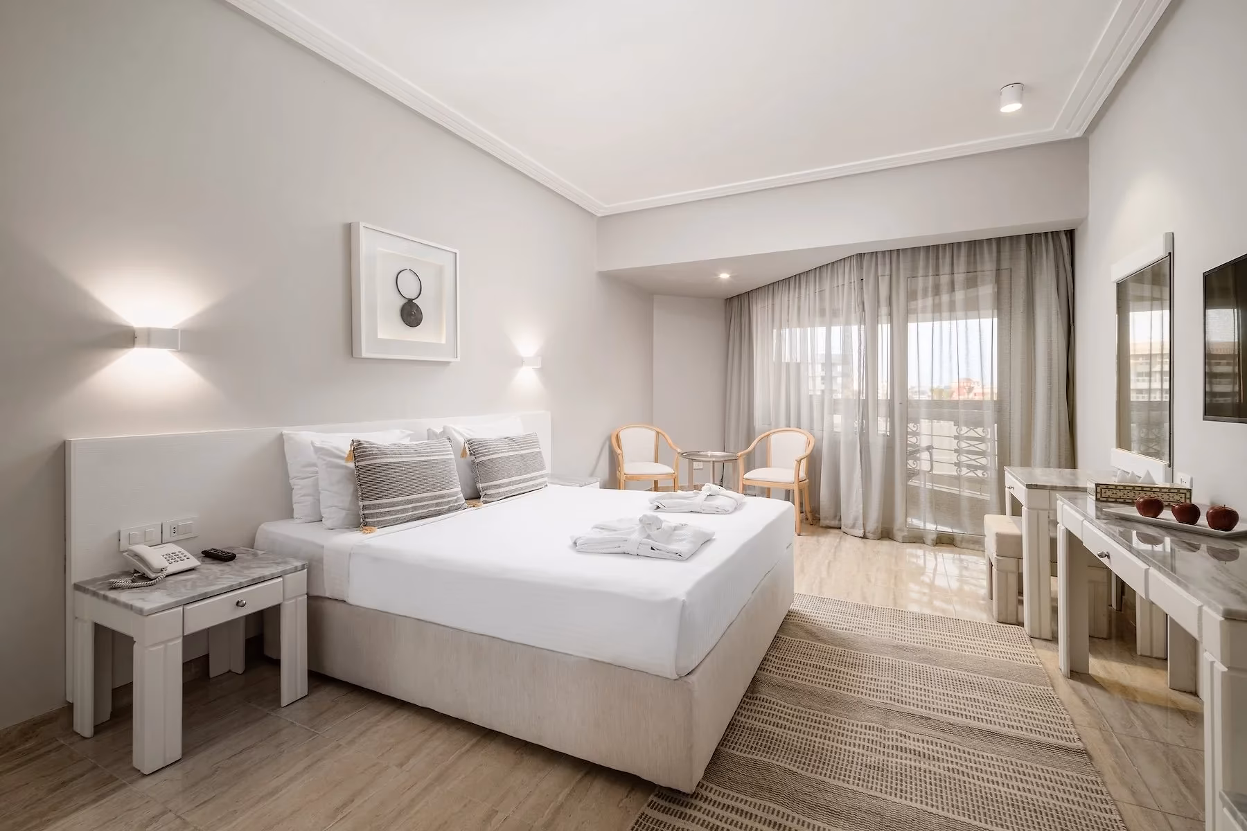 Hoofdslaapkamer van de Superior familiesuite met kingsize bed en balkondeur in Hotel Sindbad Club in Hurghada