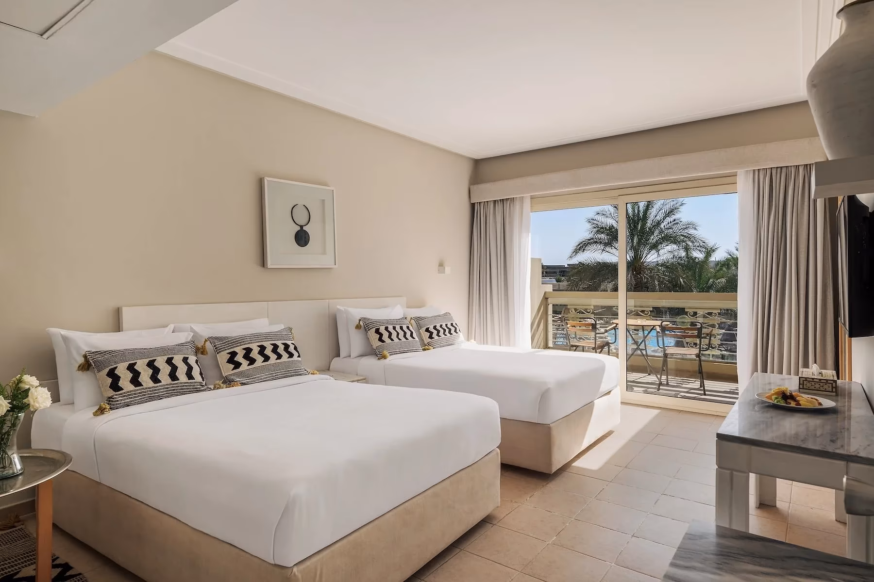 Kamer met tweepersoonsbed, eenpersoonsbed en balkon met zwembadzicht in de Superior familiesuite van Hotel Sindbad Club in Hurghada