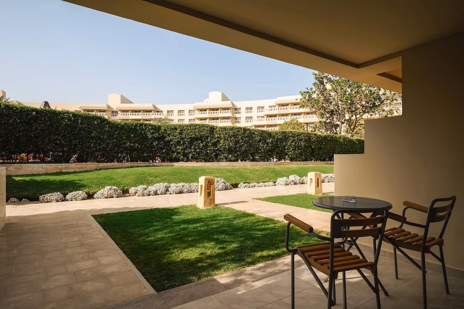 Terras op de begane grond met tafel en stoelen aan een gazon bij Hotel Sindbad Club in Hurghada