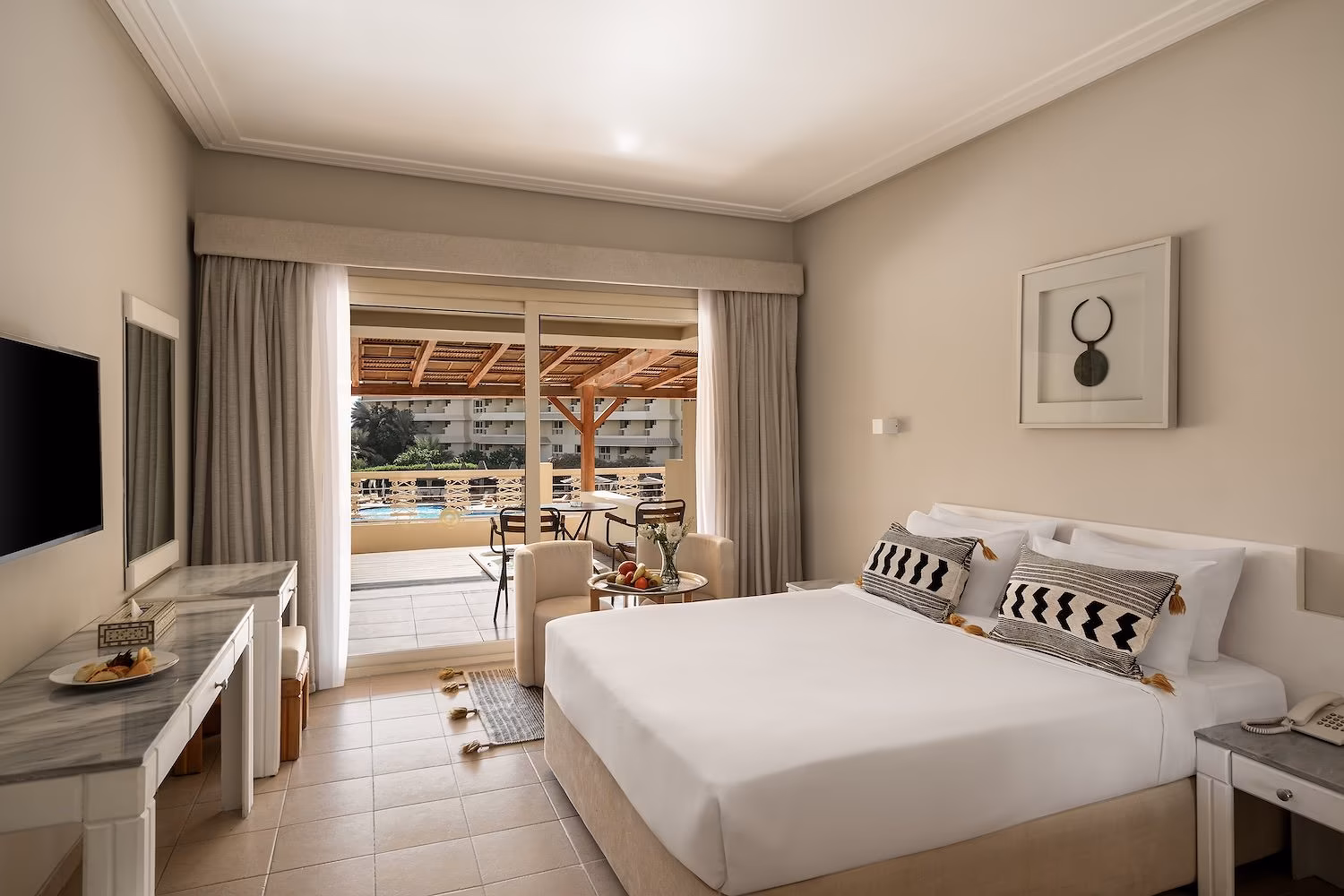 Slaapkamer van de wellnesskamer met kingsize bed en open schuifpui naar het terras met pergola in Hotel Sindbad Club in Hurghada